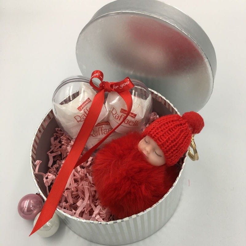 Srebrne okrągłe pudełko na prezent z różowym wypełniaczem