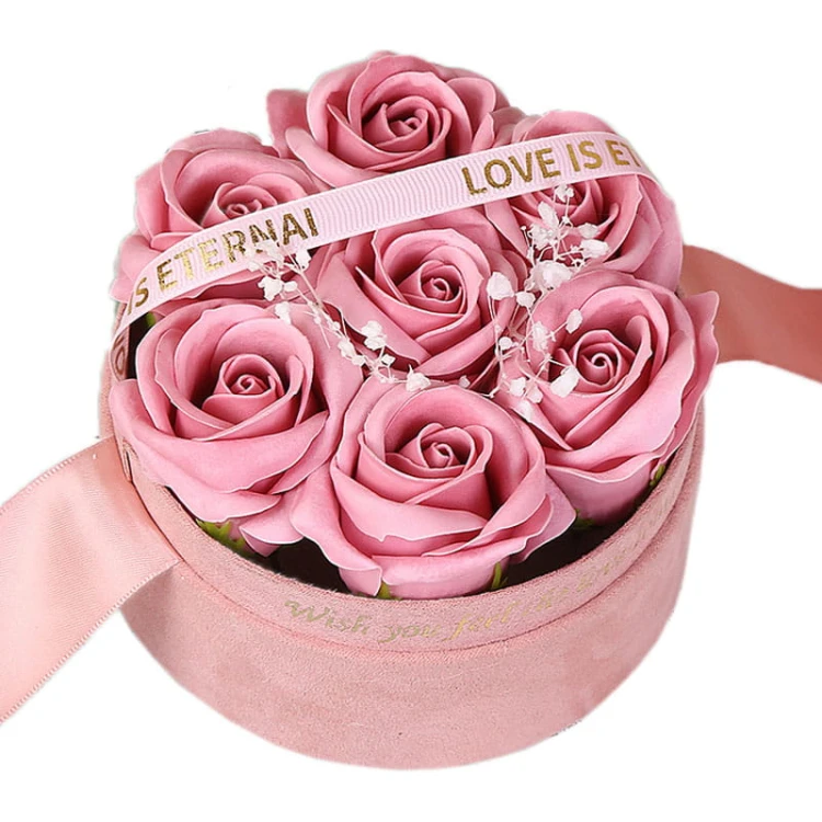 Prezent urodzinowy dla niej - Belgiskie Różowе mydlane kwiatyOkrągły flowerbox z różowymi mydlanymi różami i ozdobną wstążką „Love is Eternal” – elegancki prezent dla kobiety.