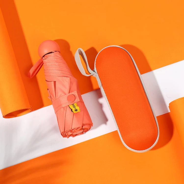 Mini parasolka w kapsule – kolor pomarańczowy. UPF50+, składana do 18 cm, z twardym etui – idealna do torebki lub na prezent.